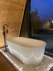 a white bath tub sitting in a room with a window at Kuro cottage- A frame in Kazbegi +46 photos