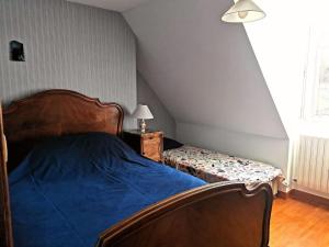 a bedroom with a bed with a blue comforter at Maison Chez la Malie in Le Monteil