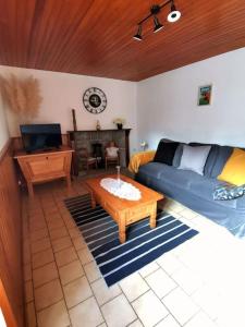a living room with a blue couch and a table at Maison Chez la Malie in Le Monteil