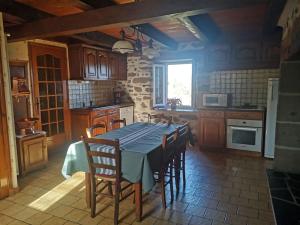 a kitchen with a table and chairs in a room at Maison Chez la Malie in Le Monteil