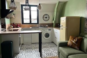 a kitchen with a refrigerator and a washing machine at Tout à pied Dourdan Appartement in Dourdan