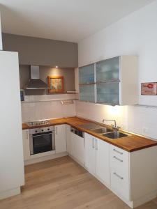 a kitchen with white cabinets and a sink at VINC & TROTTI HOUSE OF DÈJÀ-VU in Pergine Valsugana