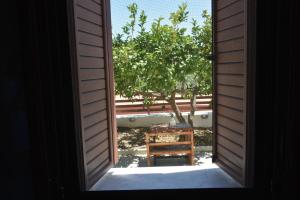 an open door to a yard with a table and a tree at Lithos House in Monólithos