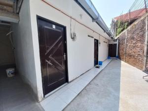 a large black door on a white building at Hotel O Jm Guest House 2NearStasiun karawang in Pundong