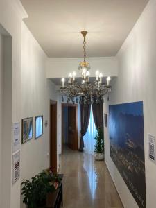 un corridoio con lampadario a braccio in una casa di Panoramic Rooms Salerno Affittacamere a Salerno