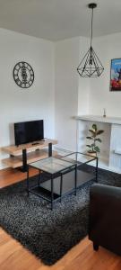 a living room with a coffee table and a tv at Appartement Centre ville proche gare in Dunkerque