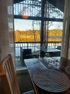 a dining room table with a view of a large window at Koivurannan Lomamökit Kielo in Mikkeli