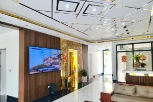 un vestíbulo con TV de pantalla plana en la pared en Hồng Ngọc Hotel en Ðông Thôn