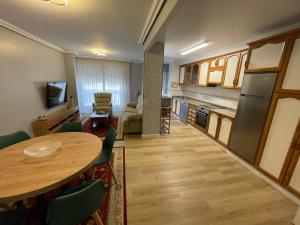 a living room with a table and a kitchen at A casa da Abunana in Cangas de Morrazo