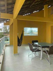 a patio with a table and chairs and a hammock at Casa do Mar Stella Maris in Salvador