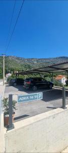 un coche aparcado en un estacionamiento con un cartel en Adria House Dubrovnik by the sea en Zaton