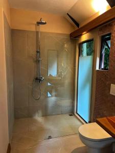 a bathroom with a shower with a toilet in it at Almonds and Corals Jungle Resort in Puerto Viejo