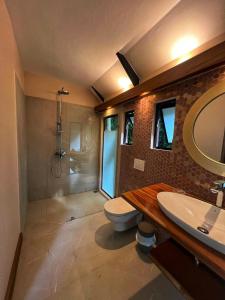 ein Bad mit einem WC, einem Waschbecken und einer Dusche in der Unterkunft Almonds and Corals Jungle Resort in Puerto Viejo