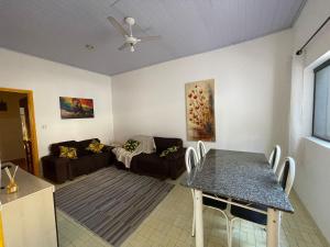 a living room with a table and a couch at Casa Praia Grande in Praia Grande