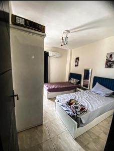Zimmer mit 2 Betten und einer Tür zu einem Schlafzimmer in der Unterkunft Chalet Grand Hills North coast in Dawwār al Ḩajj Aḩmad