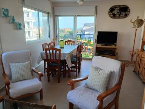 a living room with a table and chairs and a television at Peñiscola Playa FRENTE AL MAR in Peniscola