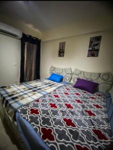 ein Schlafzimmer mit einem Bett mit einer Steppdecke darauf in der Unterkunft Chalet Grand Hills North coast in Dawwār al Ḩajj Aḩmad