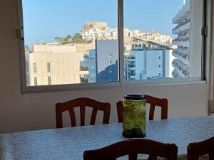 a table with chairs and a green jar on it at Peñiscola Playa FRENTE AL MAR in Peniscola