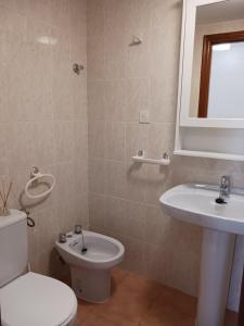 a bathroom with a white toilet and a sink at Peñiscola Playa FRENTE AL MAR in Peniscola +17 photos