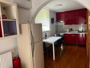 eine Küche mit roten Schränken und einem weißen Kühlschrank in der Unterkunft Apartma Jure in Zgornje Gorje