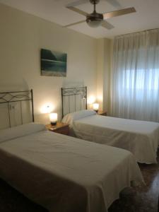 une chambre avec deux lits et un ventilateur de plafond dans l'établissement Piso La Pista Alcora, à Alcora