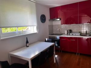 a kitchen with red cabinets and a white counter top at Apartma Jure in Zgornje Gorje