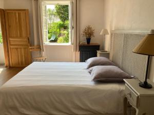 a bedroom with a large white bed with a window at Ker Heol in Saint Malo