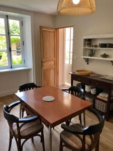 a dining room with a wooden table and chairs at Ker Heol in Saint Malo