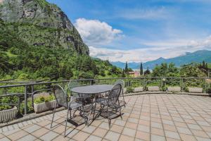 una mesa y sillas en un balcón con montañas en Mansarda Amore, en Cadenabbia