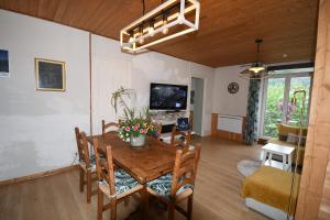 a dining room with a table and chairs and a television at Villa Lutel in Le Bourg-dʼOisans