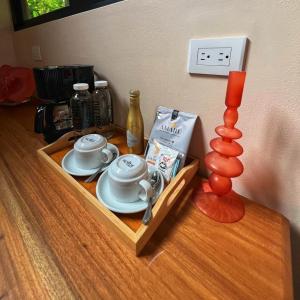 einen Holztisch mit einem Tablett mit Teetassen und einer Lampe in der Unterkunft Almonds and Corals Jungle Resort in Puerto Viejo