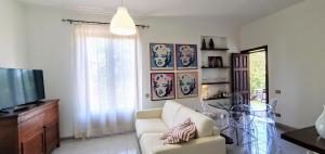 a living room with a couch and a television at Appartamento I Cipressi in Castiglione del Lago