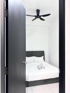a bedroom with a bed with a ceiling fan at Hakuna Matata Apartment Urban Suites Jelutong in Jelutong
