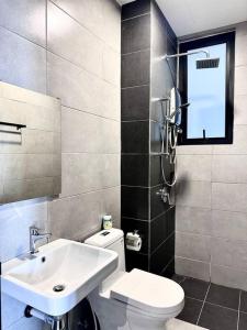 a bathroom with a sink and a toilet and a mirror at Hakuna Matata Apartment Urban Suites Jelutong in Jelutong
