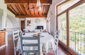 comedor con mesa y sillas y balcón en Mansarda Amore, en Cadenabbia