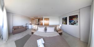 a living room with a bed and a couch at Bugan - recep 24h Estacionamento Gratuito in Recife