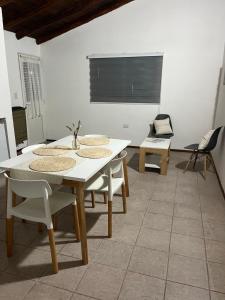 Trono de Nubes في تريفيلين: غرفة طعام مع طاولة بيضاء وكراسي