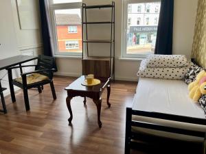 uma sala de estar com uma cama e uma mesa em Entire YellowApt near Belfast City Centre - Free parking - Up to 3 guests - 2 beds em Belfast
