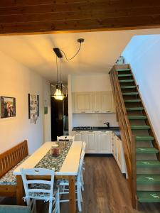 a kitchen with a dining room table and a staircase at Mandi Mandi in pista in Tarvisio