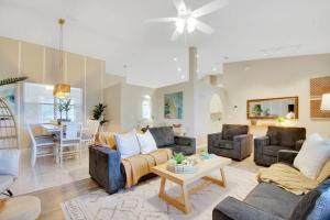 a living room with two couches and a table at Game room ,Saltwater ,pool Spa - Tropical Oasis! in Palm Coast