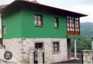 un bâtiment vert avec des fenêtres dans l'établissement Casa Rural Juaco, à Bimenes