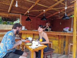 a man and woman sitting at a table in a restaurant at Silaa Cabana in Trincomalee