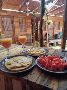 einen Tisch mit Teller mit Lebensmitteln und zwei Gläsern Orangensaft in der Unterkunft Silaa Cabana in Trincomalee