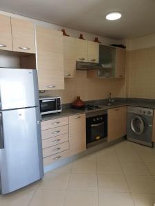 a kitchen with a white refrigerator and a microwave at Assilah Marina Golf chez Ahmed in Asilah