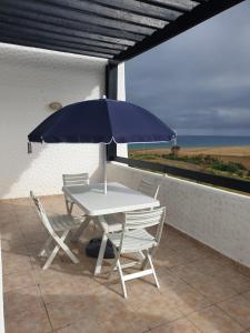 a table and chairs with an umbrella on a patio at Assilah Marina Golf chez Ahmed in Asilah +13 photos