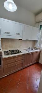 a kitchen with white cabinets and a stove top oven at Domus Le Palme in Fano