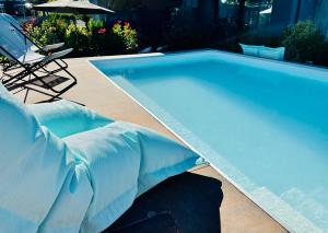una piscina blu con sedia e ombrellone di Boutique Hotel Sirmione a Sirmione