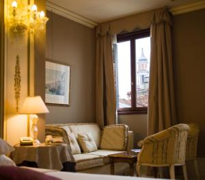 ヴェネツィアにあるカ サグレド ホテルのリビングルーム(ソファ、テーブル付)、窓が備わります。