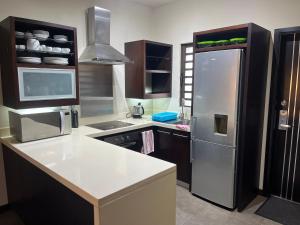 a kitchen with a stainless steel refrigerator and cabinets at Cosy Appartement in Domaine des Alizée in Grand Baie +3 photos