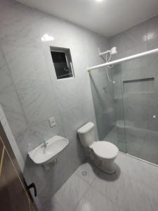 a bathroom with a toilet and a shower and a sink at Condomínio Tribu 02 in Caruaru